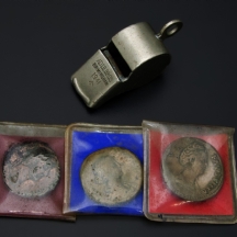 לוט הכולל משרוקית משנת 1941 ושלוש רפליקות של מטבעות עתיקים.