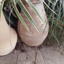 כד חרס לגינה בגוון חום, מעוטר בדוגמה היקפית מחורצת, מעמד ברזל יעודי