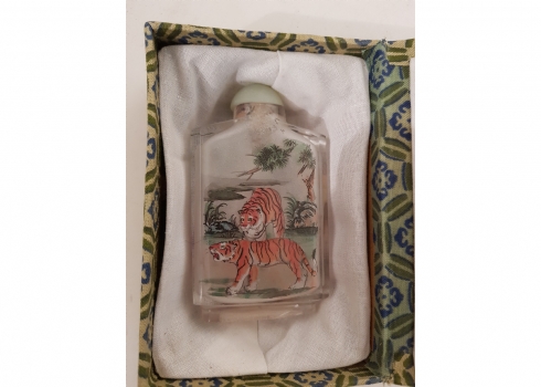בקבוק הרחה סיני (Snuff bottle) עשוי זכוכית מעוטר בתוכו בציור נמרים