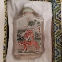 בקבוק הרחה סיני (Snuff bottle) עשוי זכוכית מעוטר בתוכו בציור נמרים