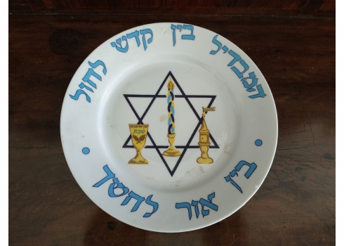 צלחת פורצלן ישראלית מעוטרת בכיתוב: מבדיל בין קודש לחול בין אור לחושך'