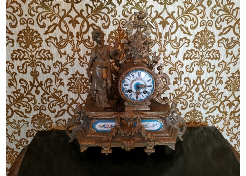 שעון קמין צרפתי עתיק עשוי ברונזה ופליז, מעוטר בדמות אישה מפוסלת ועל ידה פרפר