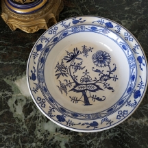 מעוטר בכחול קובלט בדגם 'הבצל הכחול' (Blue Onion) הידוע גם כ: 'צביבלמוסטר'