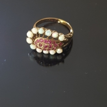 טבעת עתיקה עשויה זהב משובצת במרכזה כיפת אבני רובי אדומות ובהיקף בצורת פרסת סוס
