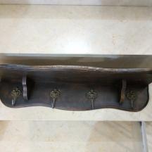 מדף עץ עתיק ועליו ארבעה ווי תליה עשויים פליז, כולל חריץ להעמדת צלחות נוי