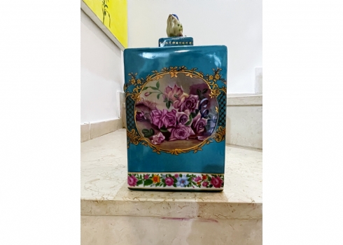 מיכל גדול ומכסה תואם עשויים חרס מעוטר בהדפס של שושנים פורחות ובזהב על רקע טורקיז
