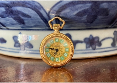 תליון ישן מעוצב בצורת שעון כיס עשוי מתכת מצופה זהב. השעון לא נפתח ולא נבדק מצבו