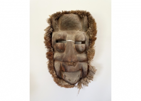 מסכה אפריקאית עתיקה, דמות פני גבר צוחק, עשויה עץ וקש בהיקף, מעוטרת פיסות מתכת