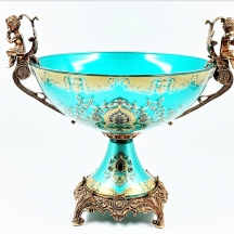 סנטרפיס בסגנון עתיק, עשוי זכוכית מעוטרת בזהב על רקע בגוון ירוק והתקני מתכת