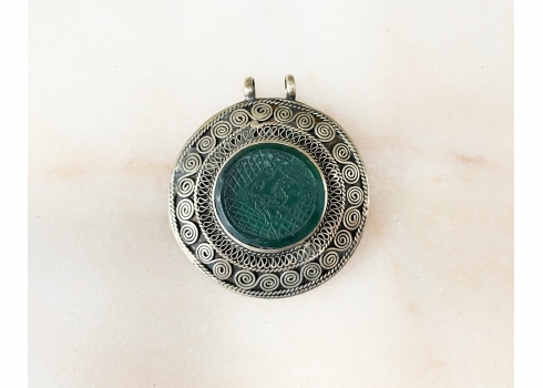 תליון טורקמני ישן עשוי כסף נמוך, משובץ במרכזו אבן ירוקה מעוטרת באינטאגליו