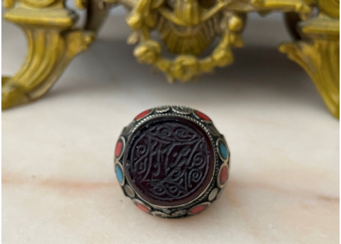 טבעת טורקמנית ישנה עשויה כסף נמוך משובצת במרכזה אבן בגוון בורדו חרוטה באינטאגליו