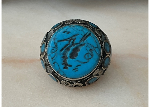 טבעת טורקמנית ישנה עשויה כסף נמוך משובצת במרכזה אבן טורקיז חרוטה באינטאגליו