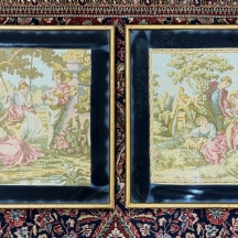 זוג תמונות גובלן (עבודת מכונה) ממוסגרות, המתארות סצנות חיזור גאלנטיות על רקע גן