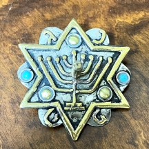 סביבון בסגנון טורקמני מעוטר מגן דוד ובתוכו המנורה, עשוי מתכת מצופה כסף