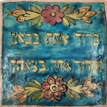 אריח קרמיקה פרסי דקורטיבי מעוטר בכיתוב עברי: "ברוך אתה בבאך וברוך אתה בצאתך'