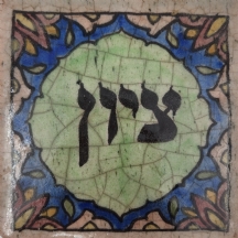 אריח קרמיקה פרסי דקורטיבי מעוטר בכיתוב עברי: 'ציון'