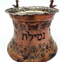 נטלה פרסית ישנה ויפה מעוטרת בעבודת ריקוע ידנית ובכיתוב עברי, שתי ידיות מעוטרות