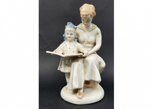 פסל פורצלן בדמות של ילדה מקריאה מספר