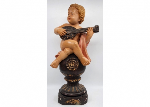 פסל ישן וגדול בדמות מלאך מנגן בגיטרה, עשוי חומר יצוק