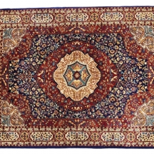 שטיח מכונה ישן דגם פרסי, בגוון בורדו, במרכזו מדליון עגול לבן מסוגנן