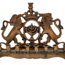 חנוכייה ישנה מהמחצית הראשונה של המאה העשרים, עשויה פליז יצוק, מעוטרת בדמות אריות