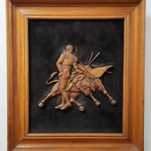 'שור אמיץ נוקם במטאדור אכזר' - תבלי עץ מגולף מוצמד ללוח מחופה בד שחור