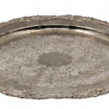 מגש גדול עגול ומרשים, עשוי מתכת מצופה כסף, חתום, נתמך על גב שלוש רגליות, מעוטר