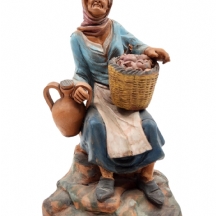 פסלון קרמיקה ישן בדמות ישישה נושאת שנאפס אפרסקים