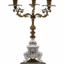 קנדלברה שולחנית ישנה ויפה עשויה פליז מוזהב ופורצלן, בראשה דמות מפוסלת של ילד