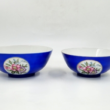 זוג קערות פורצלן יפניות בסגנון בוכרי, מעוטרות בהדפסים פרחוניים על רקע כחול