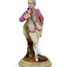 פסל פורצלן עתיק בדמות אציל במקטורן סגול, מעוטר בצביעת יד באמייל ובזהב, חתום