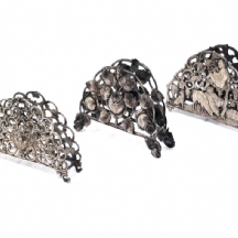 שלושה מחזיקי מפיות מעוטרים, עשויים כסף, אחד חתום HAZORFIM 800