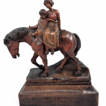 פסל עץ בדמות אישה וילד על גב סוס