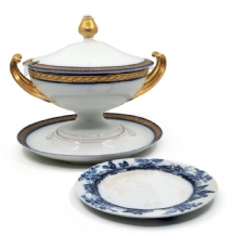 שני כלי פורצלן עתיקים: מרקיה עם מכסה ומעמד תואם, וצלחת מעוטרת בהדפס