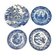 ארבע צלחות חרס שונות, כולן מעוטרות בהדפס מועבר בכחול קובלט