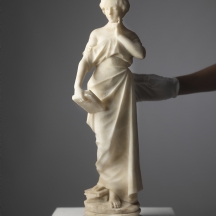 פסל שיש גדול ועתיק, מסוף המאה ה-19 או תחילת המאה ה-20, בדמות נערה וספר