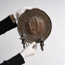 תבליט בצלאל (פמוט קיר) עשוי נחושת מעוטר בדמותם של אדם וחווה על פי זאב רבן