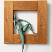 טובה אלוני - פסל ברונזה נתון במסגרת עץ, נושא תווית מתכת עם שם האמנית