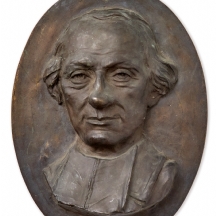 תבליט ברונזה אובאלי לתלייה על הקיר, מעוטר בפורטרט וחתום: V. Zan