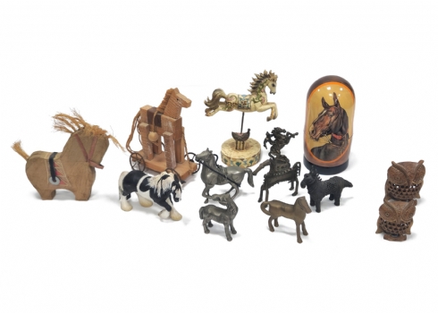 11 פסלי סוסים מחומרים שונים, כולל דמות מטריושקה בין הפסלים