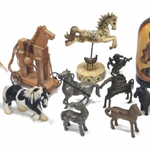 11 פסלי סוסים מחומרים שונים, כולל דמות מטריושקה בין הפסלים