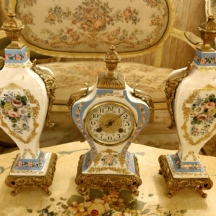 גרניטורה הכוללת שעון וזוג אגרטלים תואמים עשויים חרסינה והתקני מתכת