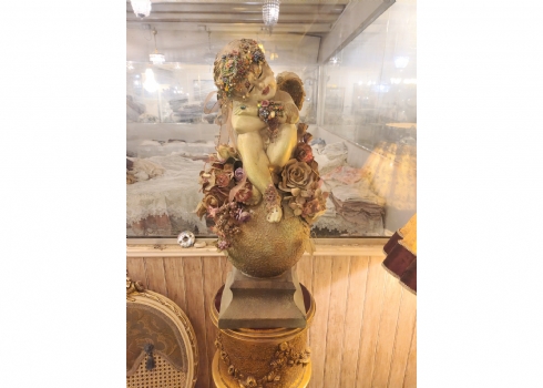 פסל בדמות מלאך ישן על כדור עשוי חומר יצוק ופרחי בד