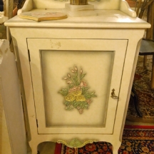 ארונית עץ בסגנון עתיק עם עיטורי פרחים על רקע בגוון שמנת