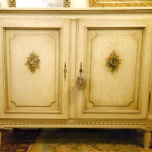 מזנון בסגנון עתיק עשוי עץ צבוע בגוון שמנת מעוטר בציורי יד בצבעי שמן של זרי פרחים