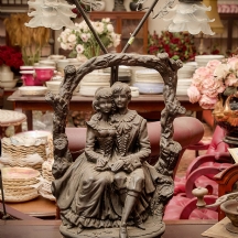 מנורה שולחנית מסיבית עשוייה חומר יצוק בדמות שני ילדים, שני אהילי זכוכית