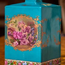 מיכל חרסינה מעוטר בהדפס שושנים על רקע בגוון טורקיז, חתום