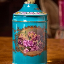 מיכל חרסינה מעוטר שושנים ורקע טורקיז, ומכסה תואם, חתום