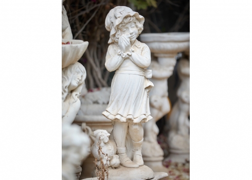 פסל גינה בדמות ילדה מחזיקה אפרוח לצד תרנגולת