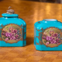 שני כלי נוי עשויים חרס מעוטרים בהדפס של שושני פורחות וזהב